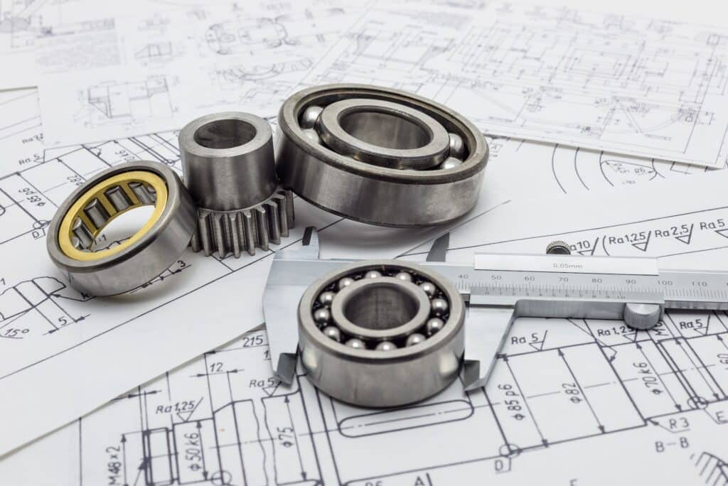 Vernier caliper lying on mechanical scheme with bearing and small gear.